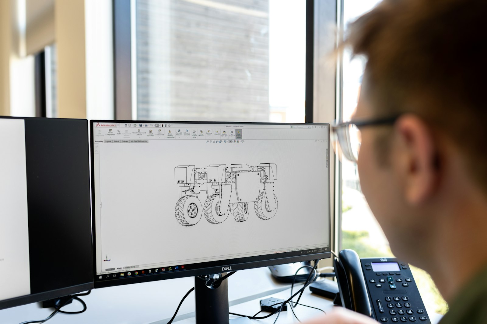 AXIS engineer reviewing CAD drawings at a workstation